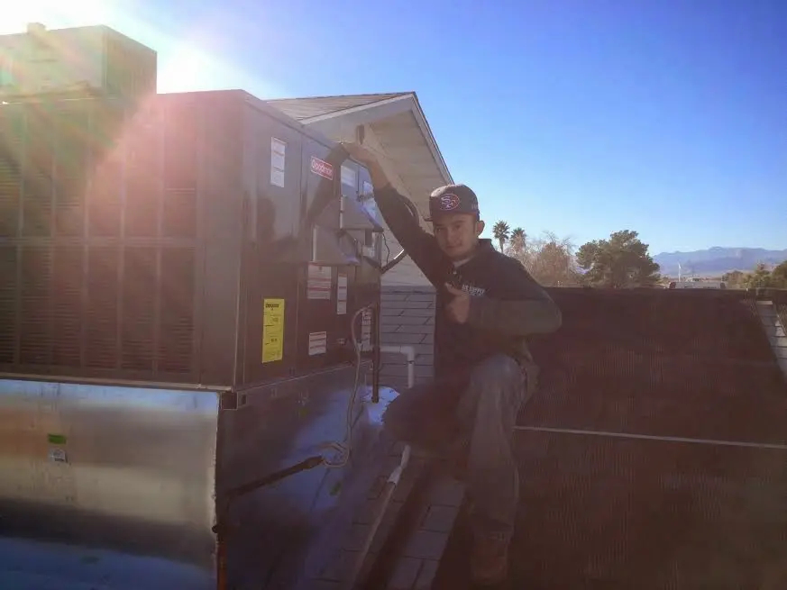 HVAC technician performing Air Duct Cleaning on a rooftop unit in Georgetown